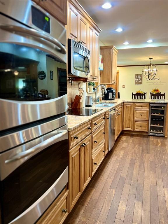 110 Mcmaster St, Bath, NY 14810 - kitchen with beverage cooler, stainless steel appliances, dark wood finished floors, a peninsula, and light stone countertops