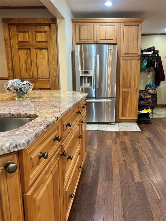 110 Mcmaster St, Bath, NY 14810 - kitchen with stainless steel fridge, dark wood-type flooring, light stone counters, brown cabinetry, and recessed lighting