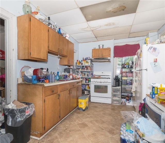 364 W 3rd St, Elmira City, NY 14901 - kitchen featuring white appliances, a paneled ceiling, under cabinet range hood, brown cabinetry, and light countertops