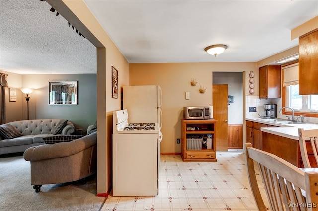 7 Cannas Ct, Cheektowaga, NY 14227 - kitchen with white appliances, brown cabinetry, light countertops, and open floor plan