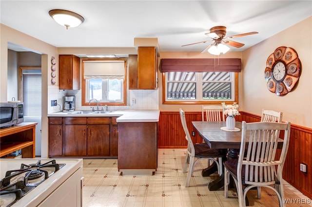7 Cannas Ct, Cheektowaga, NY 14227 - kitchen featuring stainless steel microwave, wainscoting, light countertops, a ceiling fan, and light flooring