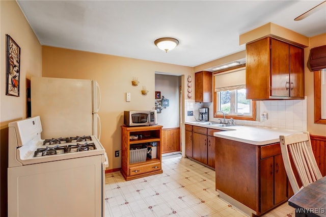 7 Cannas Ct, Cheektowaga, NY 14227 - kitchen with white appliances, light countertops, brown cabinetry, backsplash, and light floors