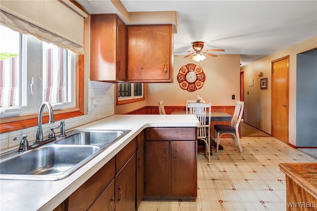 7 Cannas Ct, Cheektowaga, NY 14227 - kitchen featuring a ceiling fan, a wainscoted wall, light countertops, light flooring, and tasteful backsplash