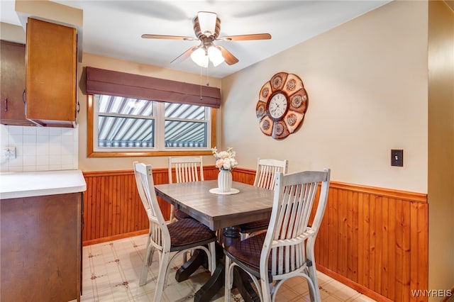 7 Cannas Ct, Cheektowaga, NY 14227 - dining room with wainscoting, wooden walls, ceiling fan, and light floors