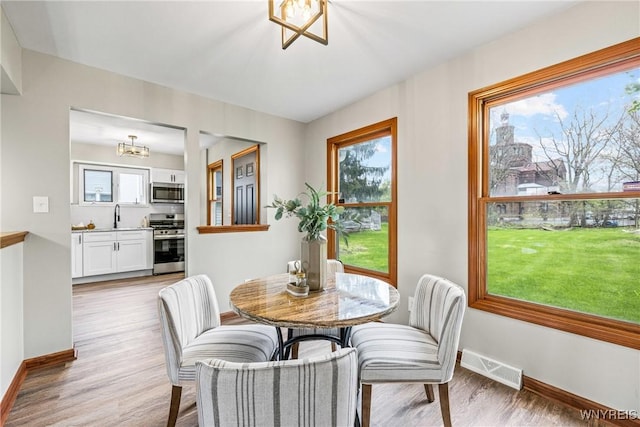 374 Dewey Ave, Buffalo, NY 14214 - dining area featuring a chandelier, plenty of natural light, and light wood-type flooring