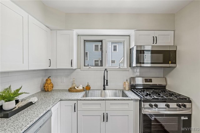 374 Dewey Ave, Buffalo, NY 14214 - kitchen with appliances with stainless steel finishes, white cabinets, tasteful backsplash, and light stone countertops