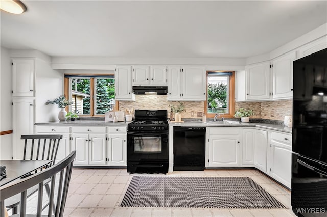 94 N Seine Dr, Cheektowaga, NY 14227 - kitchen with black appliances, under cabinet range hood, healthy amount of natural light, and backsplash