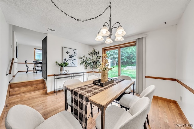 94 N Seine Dr, Cheektowaga, NY 14227 - dining room with a chandelier, a textured ceiling, and light wood-style floors