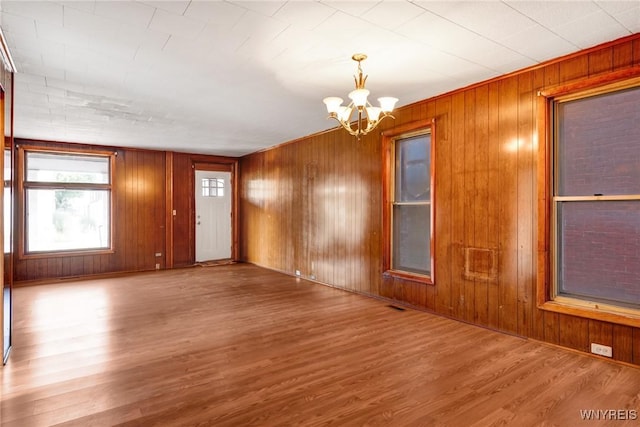 1329 Clinton St, Buffalo, NY 14206 - unfurnished room featuring a chandelier, wood finished floors, and wood walls