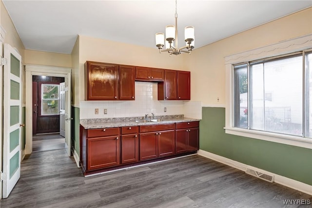 1329 Clinton St, Buffalo, NY 14206 - kitchen featuring a chandelier, healthy amount of natural light, dark wood finished floors, and decorative backsplash
