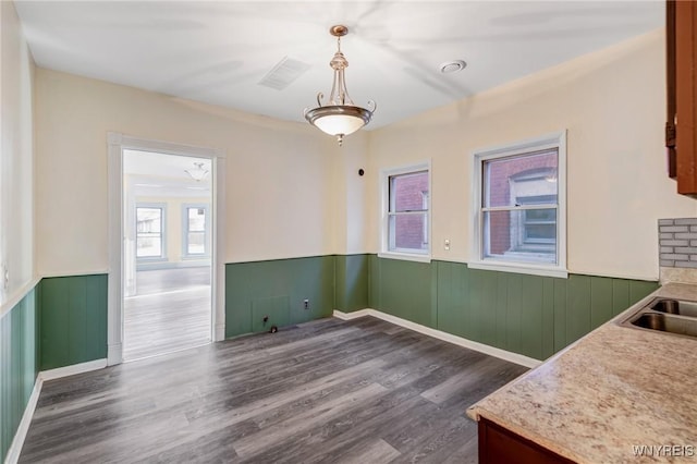 1329 Clinton St, Buffalo, NY 14206 - unfurnished dining area with a wainscoted wall and dark wood-style flooring