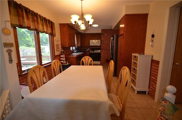 162 Miramar Rd, Gates, NY 14624 - dining space featuring a chandelier, light tile patterned floors, and brick wall