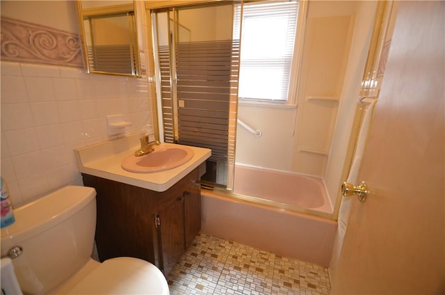 162 Miramar Rd, Gates, NY 14624 - full bathroom with vanity, bath / shower combo with glass door, tile walls, and tile patterned flooring