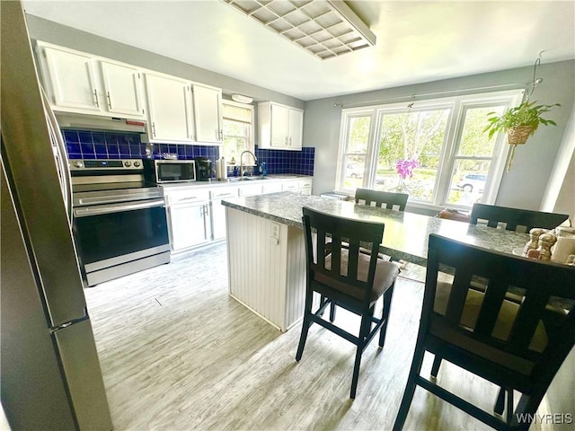 93 Century Dr, West Seneca, NY 14224 - kitchen featuring stainless steel appliances, under cabinet range hood, healthy amount of natural light, and backsplash