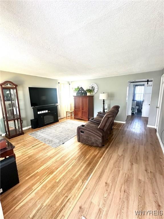 93 Century Dr, West Seneca, NY 14224 - living room featuring a textured ceiling, a barn door, and wood finished floors