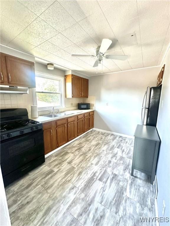 93 Century Dr, West Seneca, NY 14224 - kitchen with black appliances, under cabinet range hood, light countertops, brown cabinetry, and ceiling fan