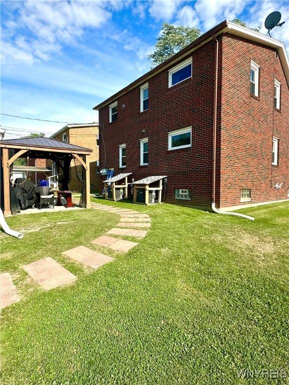 93 Century Dr, West Seneca, NY 14224 - rear view of house with a gazebo, brick siding, and a lawn