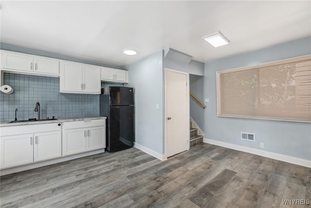 40 Decker St, Buffalo, NY 14215 - kitchen with freestanding refrigerator, white cabinetry, decorative backsplash, light countertops, and light wood-style flooring