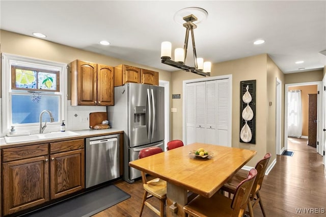 715 Brighton Rd, Tonawanda, NY 14150 - kitchen with stainless steel appliances, dark wood-style flooring, tasteful backsplash, light countertops, and decorative light fixtures