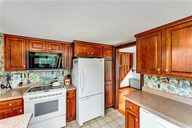 61 Country Pl, Colesville, NY 13813 - kitchen with white appliances, light countertops, brown cabinets, and light tile patterned floors