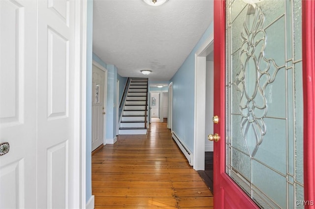 16 Onondaga St, Skaneateles, NY 13152 - foyer with a baseboard radiator, hardwood / wood-style floors, stairs, and a textured ceiling