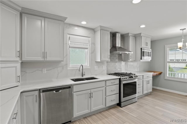 29 Raine Dr, Amherst, NY 14221 - kitchen with stainless steel appliances, wall chimney range hood, tasteful backsplash, light wood-style flooring, and light stone counters