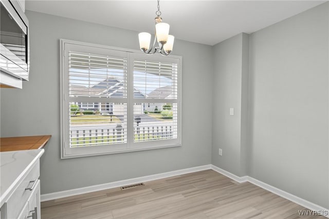 29 Raine Dr, Amherst, NY 14221 - unfurnished dining area with a chandelier and light wood-style floors