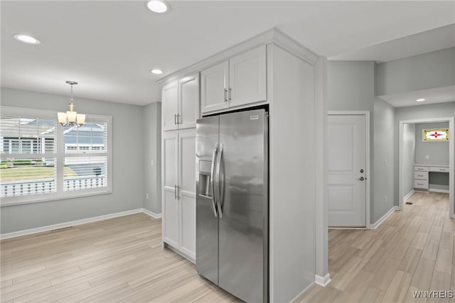 29 Raine Dr, Amherst, NY 14221 - kitchen with stainless steel fridge, light wood-style flooring, white cabinets, recessed lighting, and a chandelier