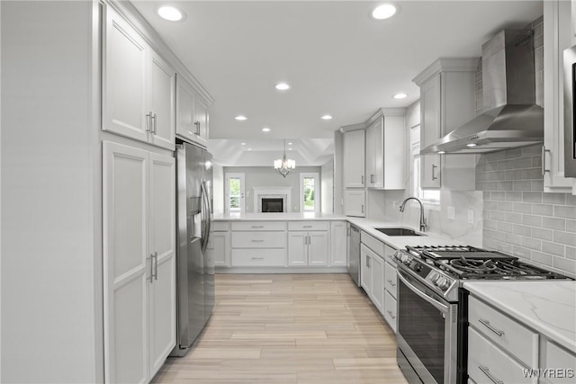 29 Raine Dr, Amherst, NY 14221 - kitchen featuring wall chimney exhaust hood, stainless steel appliances, decorative backsplash, recessed lighting, and light wood-style flooring