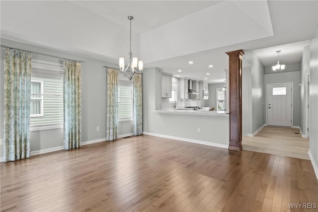 29 Raine Dr, Amherst, NY 14221 - unfurnished living room featuring a chandelier, hardwood / wood-style floors, ornate columns, and recessed lighting