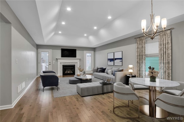 29 Raine Dr, Amherst, NY 14221 - living room featuring a chandelier, light wood finished floors, a tray ceiling, recessed lighting, and a fireplace