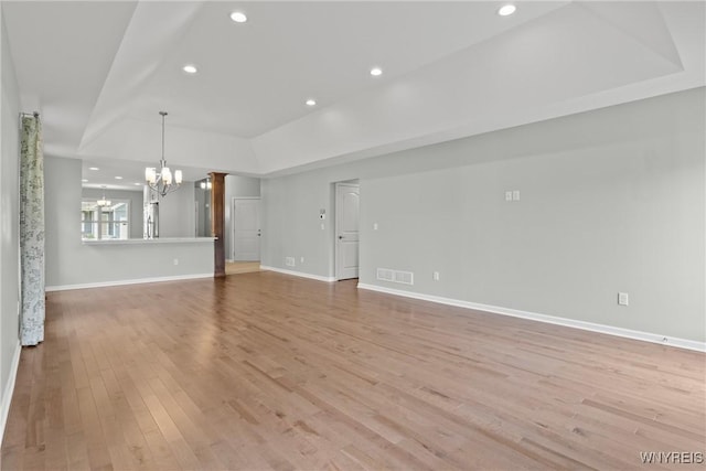 29 Raine Dr, Amherst, NY 14221 - unfurnished living room featuring a chandelier, a tray ceiling, light wood-style floors, and recessed lighting