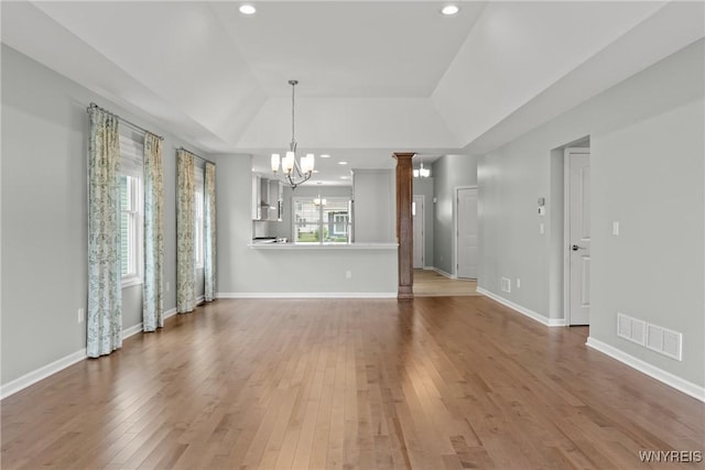 29 Raine Dr, Amherst, NY 14221 - unfurnished living room with a chandelier, wood finished floors, recessed lighting, a tray ceiling, and vaulted ceiling