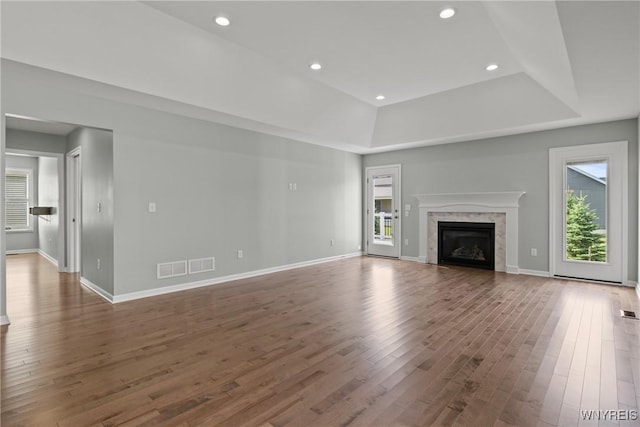 29 Raine Dr, Amherst, NY 14221 - unfurnished living room featuring plenty of natural light, a tray ceiling, wood finished floors, a premium fireplace, and recessed lighting