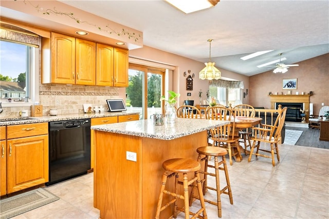 35 Silkwood Cir, Gates, NY 14559 - kitchen featuring black dishwasher, a skylight, ceiling fan, a breakfast bar, and light stone countertops