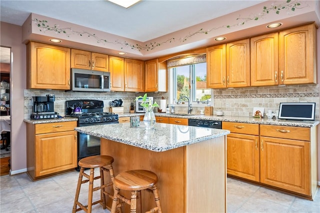 35 Silkwood Cir, Gates, NY 14559 - kitchen with black appliances, light stone counters, a kitchen breakfast bar, a kitchen island, and decorative backsplash