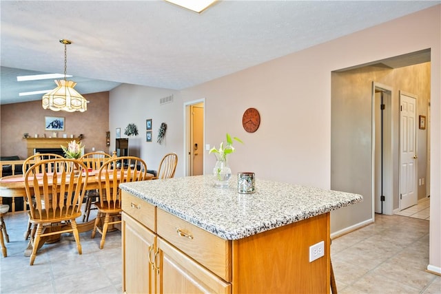 35 Silkwood Cir, Gates, NY 14559 - kitchen featuring a center island, light tile patterned floors, light stone counters, a fireplace, and pendant lighting