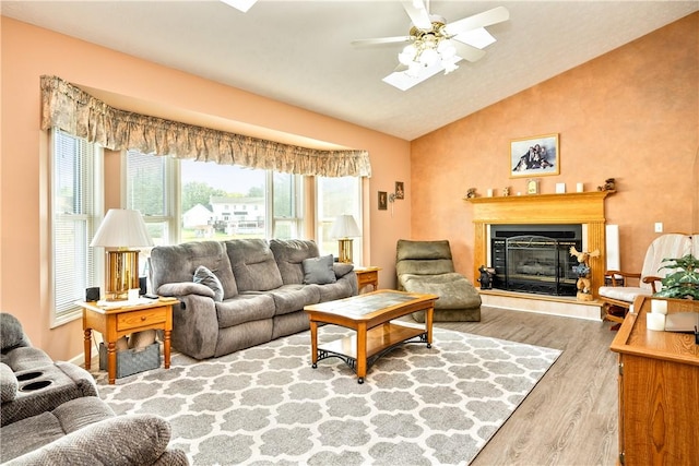 35 Silkwood Cir, Gates, NY 14559 - living area with wood finished floors, vaulted ceiling, a glass covered fireplace, and ceiling fan