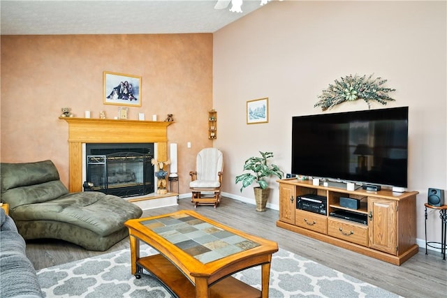 35 Silkwood Cir, Gates, NY 14559 - living room featuring wood finished floors, a glass covered fireplace, and lofted ceiling