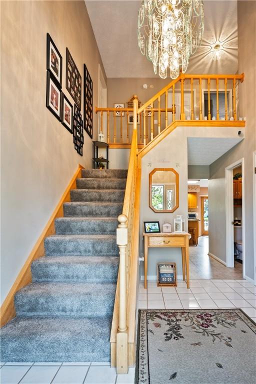 35 Silkwood Cir, Gates, NY 14559 - stairs with tile patterned flooring, a chandelier, and a towering ceiling