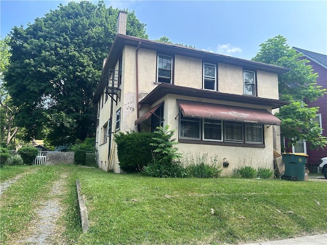 182 Parsells Ave, Rochester, NY 14609 - view of front of house featuring stucco siding, a front yard, and a chimney