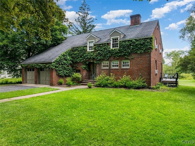 53 Payne St, Hamilton, NY 13346 - view of front of home with a chimney, asphalt driveway, a front yard, brick siding, and an attached garage