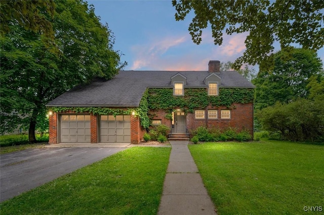 53 Payne St, Hamilton, NY 13346 - view of front facade featuring a front lawn, brick siding, a garage, and asphalt driveway