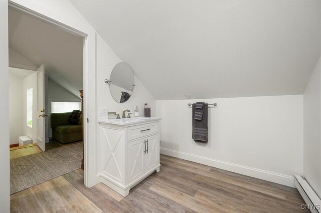 53 Payne St, Hamilton, NY 13346 - bathroom featuring a baseboard radiator, lofted ceiling, wood finished floors, and vanity
