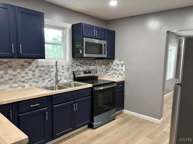 196 Berger Ave, Syracuse, NY 13205 - kitchen featuring stainless steel appliances, blue cabinetry, light wood finished floors, decorative backsplash, and recessed lighting
