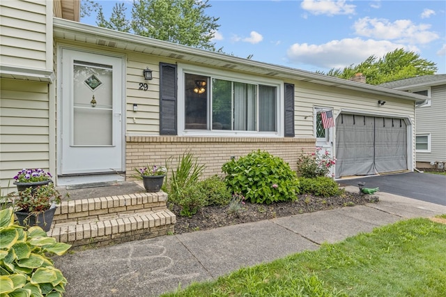 29 Davy Dr, Gates, NY 14624 - property entrance featuring driveway, brick siding, and an attached garage
