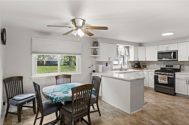 29 Davy Dr, Gates, NY 14624 - kitchen featuring stainless steel appliances, a ceiling fan, white cabinets, and tasteful backsplash