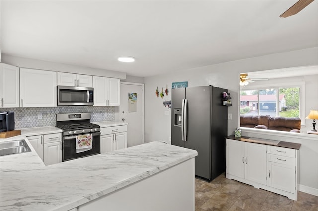 29 Davy Dr, Gates, NY 14624 - kitchen with appliances with stainless steel finishes, ceiling fan, backsplash, a peninsula, and white cabinets