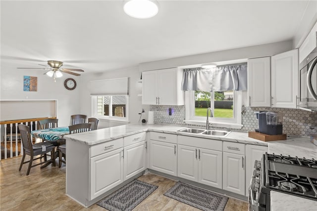 29 Davy Dr, Gates, NY 14624 - kitchen featuring a peninsula, decorative backsplash, appliances with stainless steel finishes, and ceiling fan