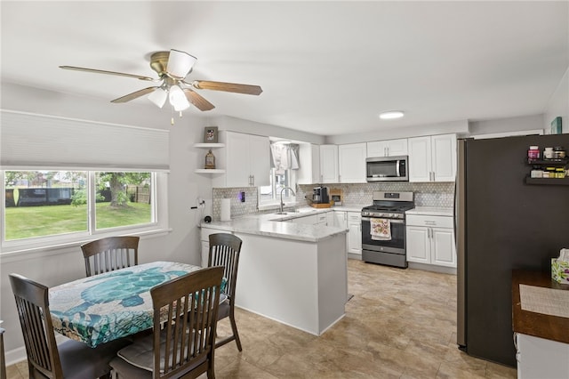 29 Davy Dr, Gates, NY 14624 - kitchen with appliances with stainless steel finishes, a peninsula, white cabinetry, and backsplash